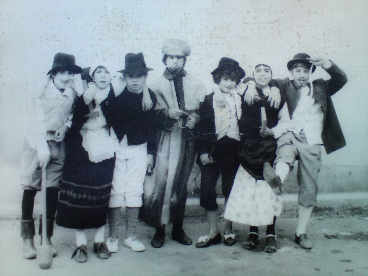 Photographie en noir et blanc de personnes costumées, présentées dans la publication comme les danseurs du Roumégaïre.
